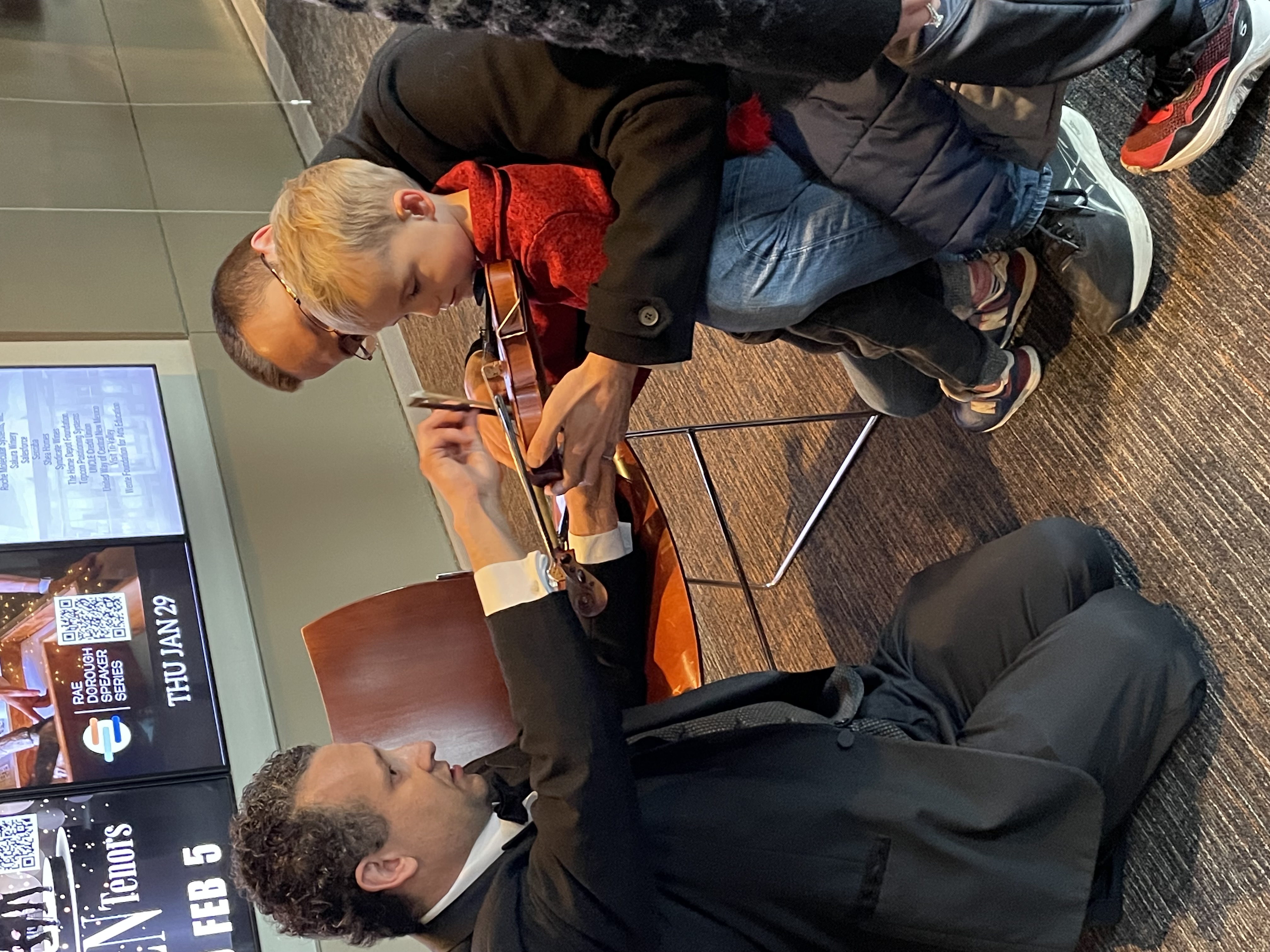 child meets violin with LAS player Nick Travia